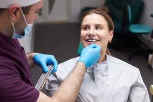 The image depicts a diverse group of dental professionals discussing the Canadian Dental Care Plan (CDCP) in a modern clinic setting, emphasizing the importance of understanding the range of dental services covered, such as preventive and orthodontic care. This collaboration among oral health providers highlights the goal of making comprehensive oral health care accessible to eligible Canadian residents.